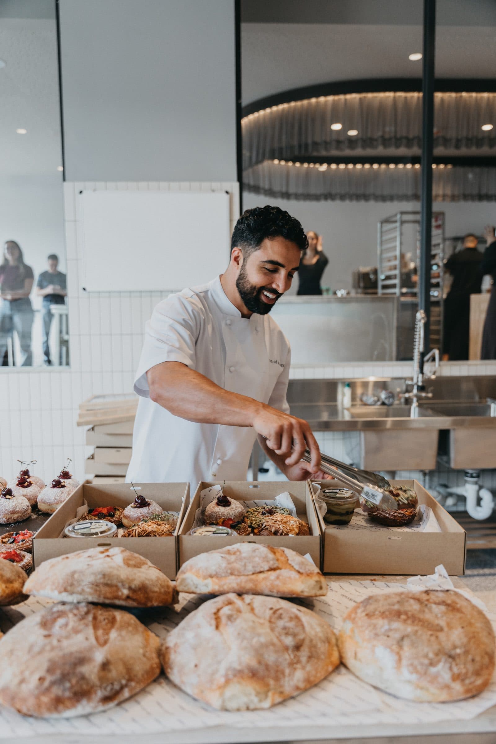 A Son of a Baker baker plating pastries at the pass
